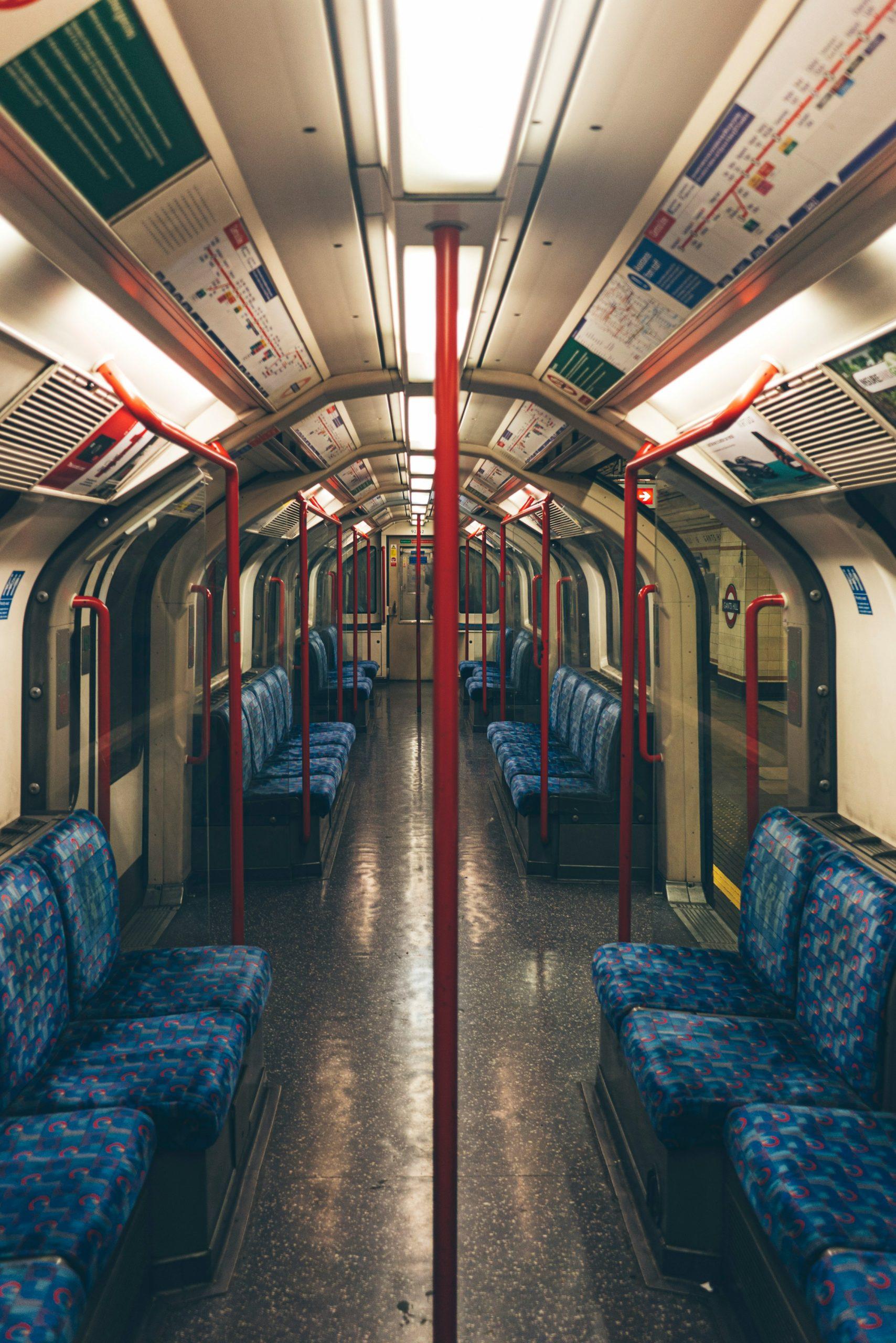 an image of an empty underground train. The seats are blue